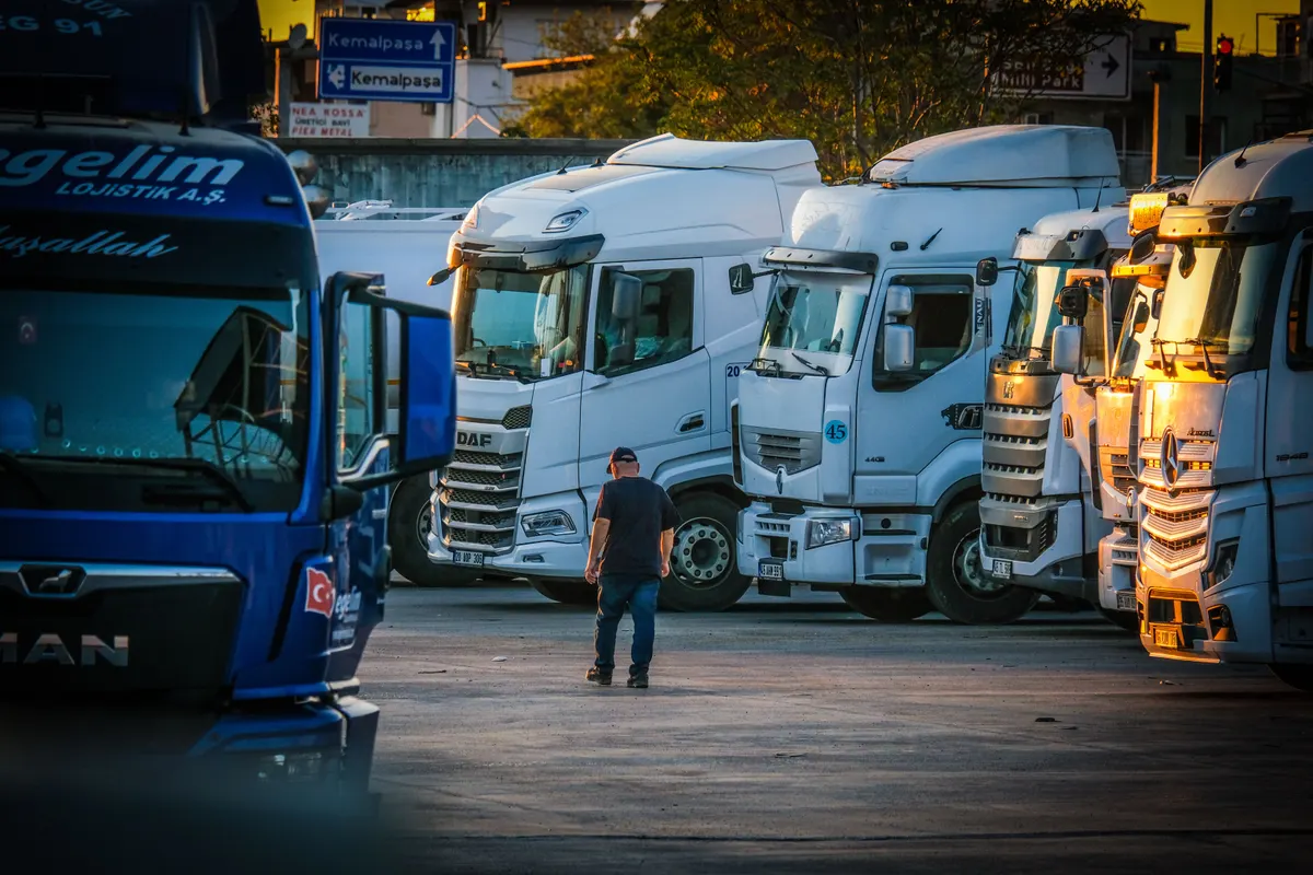 Frota de caminhões estacionados lado a lado em pátio de transportadora