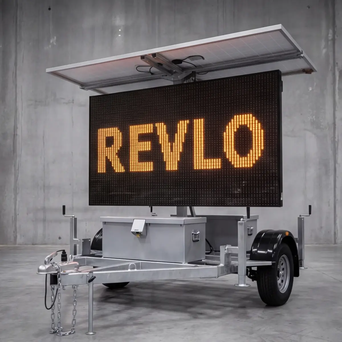 Painel de mensagem variável móvel Revlo visto de frente, com a palavra REVLO acesa em LED âmbar e as placas fotovoltaicas abertas sobre a tela